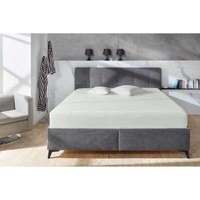 Boxspring-Spannbetttuch in Hellgrau auf einem grauen Boxspringbett in einem Schlafzimmer; zwei helle Kissen liegen am Kopfende; Größe 100 x 200 x 38 cm.