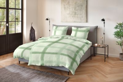 Doppelbett mit grün-weißer Bettwäsche im großflächigen Karomuster; Größe 135 x 200 cm.