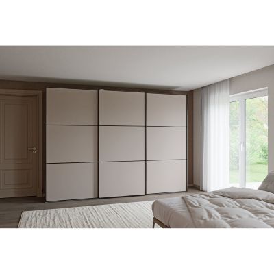 Breiter Schwebetürenschrank mit drei geschlossenen Türen in einem eingerichteten Schlafzimmer