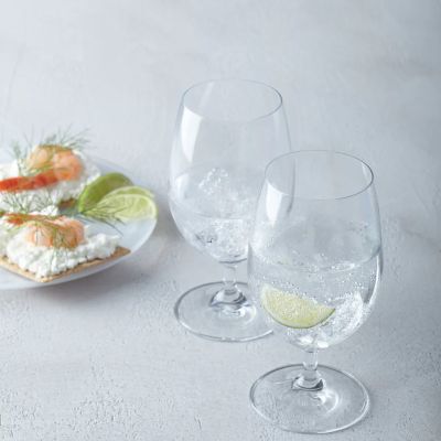 Zwei Universalgläser mit Getränk auf gedecktem Tisch mit Snacks