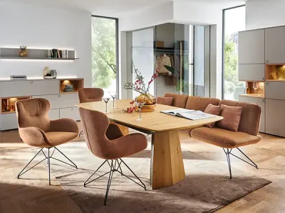 Modernes Esszimmer mit Tisch in Holzoptik, gepolsterten Stühlen in Macchiato-Farben sowie Möbeln in Grau und Weiß