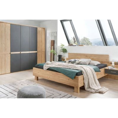 Modernes Schlafzimmer mit Doppelbett in Holzoptik, Nachttischen und großem Kleiderschrank mit dunklen Fronten unter schrägen Dachfenstern