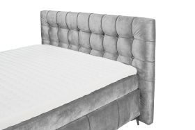 Boxspringbett in grauem Bezug, schräg aufgenommen, Fokus auf Kopfteil und Matratze, ohne Kissen