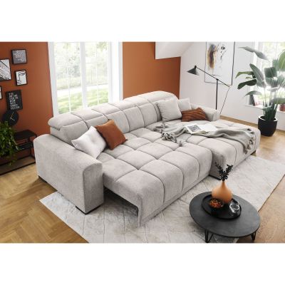 Silbergraues Schlafsofa mit großer ausgezogener Liegefläche, verstellbaren Kopfstützen, Kissen und Decke in einem hellen Wohnzimmer mit orangefarbener Wand
