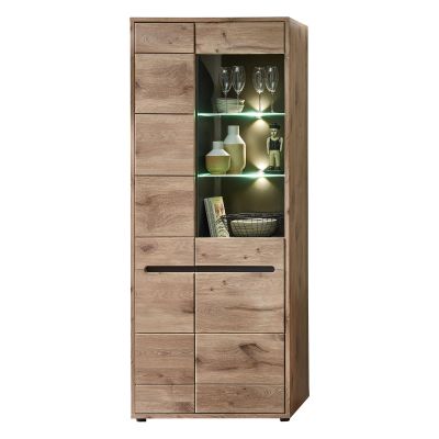 Eine hohe Vitrine in Holzoptik. Der obere rechte Bereich hat eine verglaste Tür mit zwei beleuchteten Glasböden, auf denen Dekoobjekte stehen.