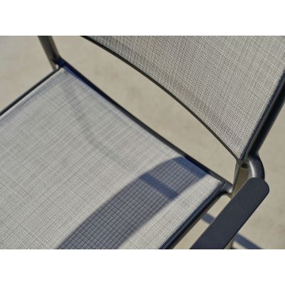 Detailaufnahme der Sitzfläche eines Gartenstuhls mit Textilbespannung und sichtbarem Schatten