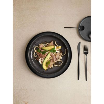 Gourmetteller der Serie Coppa, Farbe Schwarz matt in einer gedeckten Tischszene mit weiterem Geschirr.