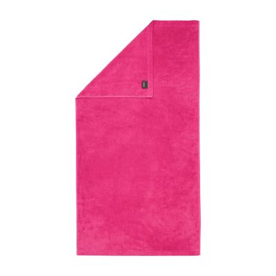 Duschtuch in der Farbe Pink mit umgeschlagener Ecke; Rückseite, Saum und kleines Textiletikett sind auf weißem Hintergrund sichtbar.