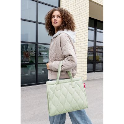 Shopper von Reisenthel, Modell Daily Shopper, in Hellgrün mit Steppstruktur, von einer Person an den kurzen Griffen getragen