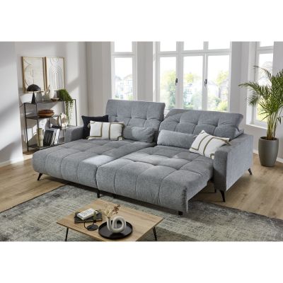 Graue Wohnlandschaft mit ausgezogener Liegefläche in modernem Wohnzimmer mit großen Fenstern, Couchtisch und Regal