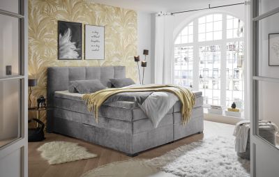 Boxspringbett „Vogue 15 grey“ in einem eingeriBchteten Schlafzimmer, dekoriert mit Kissen und Bettdecke, wohnliches Ambiente