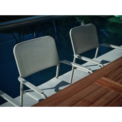 Zwei Gartenstühle mit Armlehnen an Tisch neben Wasserfläche im Außenbereich