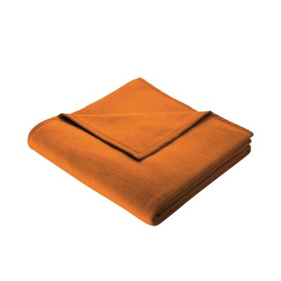 Gefaltete Wohndecke Cotton Home Curry in kräftigem Orange-Curry mit schmal eingefasster Kante auf weißem Hintergrund.