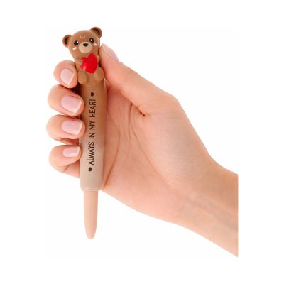 Brauner Gelstift mit Teddybär-Aufsatz, mit einer Hand am weichen Tieraufsatz gehalten und leicht gedrückt dargestellt.