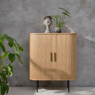 Heller Holzschrank mit Lamellenfront, dekoriert mit Pflanze und Skulptur im Wohnraum
