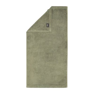Handtuch in der Farbe Field mit umgeschlagener Ecke; Rückseite, Saum und kleines Textiletikett sind auf weißem Hintergrund sichtbar.