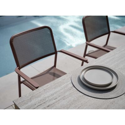 Zwei Gartenstühle mit Armlehnen an einem Tisch im Außenbereich neben einem Pool