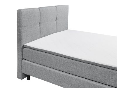 Boxspringbett „Lumos 08 grey“ aus schräger Perspektive, Fokus auf Kopfteil und Matratze, Details des grauen Stoffbezugs und der Metallfüße sichtbar
