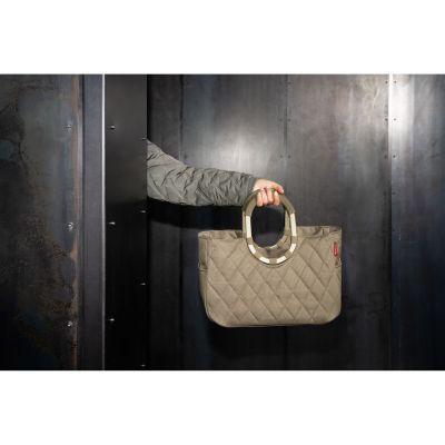Shopper von Reisenthel, Modell Loopshopper M, in Olivbeige mit Rautensteppung und hellen Rahmendetails, von einer Person an einem Ringgriff getragen.