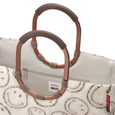 Shopper mit Ringgriffen von Reisenthel, Modell Loopshopper L, in Creme und Braun mit Smiley-Muster aus Teddyfleece, Nahaufnahme der ovalen Ringgriffe und des oberen Innenraums