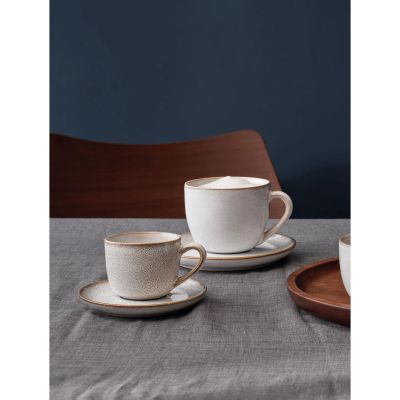 Cappuccinotasse mit Unterer der Serie Saisons, Farbe Nude in einer gedeckten Tischszene mit weiterem Geschirr.