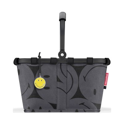 Kleiner Einkaufskorb von Reisenthel, Modell Carrybag XS, in Grau mit großflächigem Smiley-Muster, von hinten mit hochgestelltem Griff und Smiley-Anhänger.
