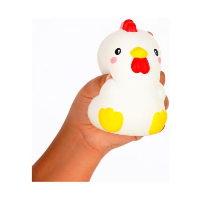 Weiße Antistress-Figur in Hühnerform, in einer Hand gehalten und leicht zusammengedrückt gezeigt.