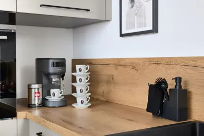 Arbeitsfläche aus heller Holzoptik mit Kaffeemaschine in moderner Interliving Küche