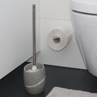 Freistehende WC Garnitur in Grau auf einem dunklen Boden neben einer weißen Toilette