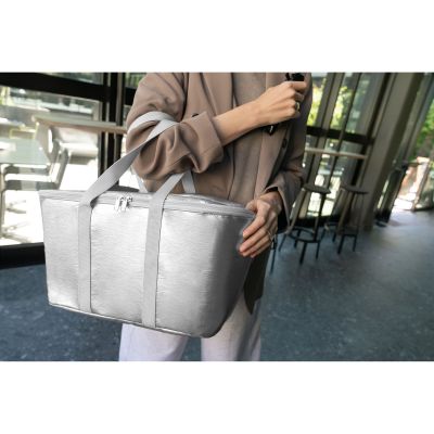 Frau trägt silberne Reisenthel Kühltasche in modernem Innenbereich