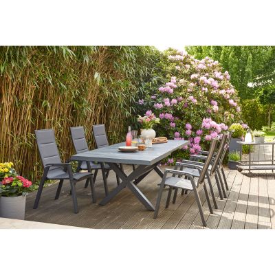 Gartenszene mit großem Esstisch und mehreren schwarzen Gartenstühlen aus Aluminium, gedeckter Tisch auf Holzterrasse