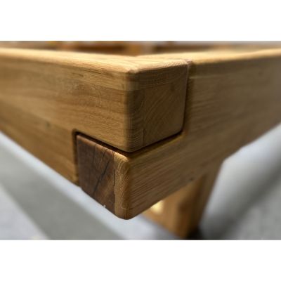 Nahaufnahme der Bettkante aus massivem Holz mit sichtbarer Holzmaserung und Eckverbindung