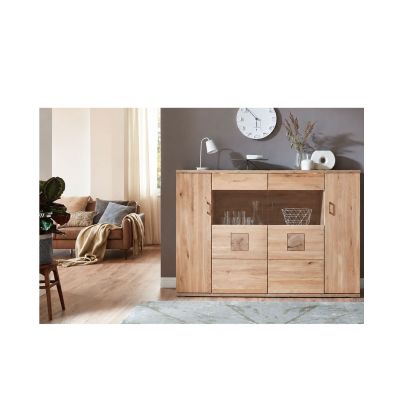 Highboard in Holzoptik vor einer hellen Wand mit Dekoration und angrenzender Sitzgruppe