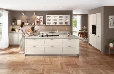 Helle Landhausküche mit klaren Linien, sanftem Sandton, verlängertem Wandboard und Glasschränken mit Sprossentüren