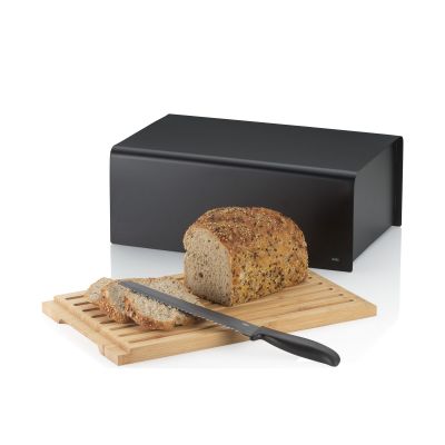 Schwarzer Brotkasten mit herausgezogenem Bambusbrett Brotlaib Brotscheiben und Messer