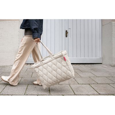 Shopper von Reisenthel, Modell Softshopper, in hellem Steinbeige mit Steppstruktur, von einer Person an den kurzen Griffen getragen