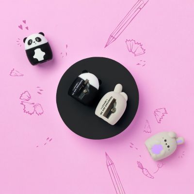 Schwarz-weißer Anspitzer im Panda-Design, in einer pinken Grafik mit abgenommenem Pandaoberteil und sichtbarem Innenraum gezeigt.