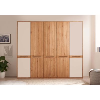 Großer Kleiderschrank mit Holzfronten und hellen Glastürflächen in einem modern eingerichteten Schlafzimmer