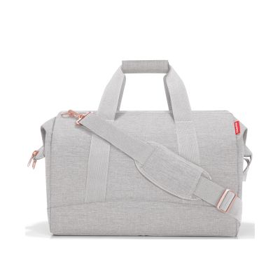 Reisetasche von Reisenthel, Modell Allrounder L, in sehr hellem Grau mit rosafarbenen Details, seitlich von vorn mit Tragegriffen und Schultergurt.