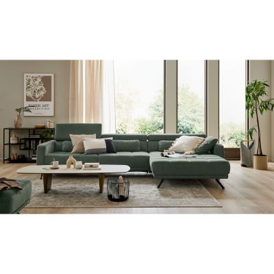 grünes Ecksofa Interliving 4303 mit linker Recamiere in einem hellen Wohnzimmer mit Couchtisch, Teppich und großen Fenstern