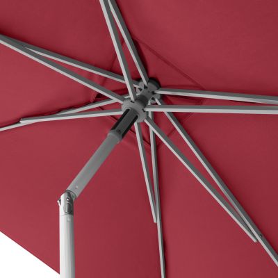 Nahaufnahme des verstellbaren Gelenks am weißen Mast eines roten Sonnenschirms zur Neigungsverstellung.