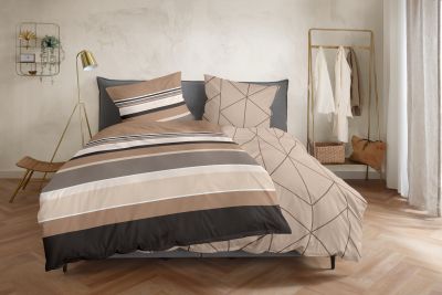 Bett mit braun-grau gestreifter Bettwäsche; ein geometrisch gemustertes Kissen und die abweichende Wendeseite sind sichtbar; Größe 135 x 200 cm.