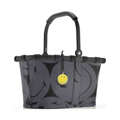 Kleiner Einkaufskorb von Reisenthel, Modell Carrybag XS, in Grau mit großflächigem Smiley-Muster, frontal mit hochgestelltem Griff und gelbem Smiley-Anhänger.