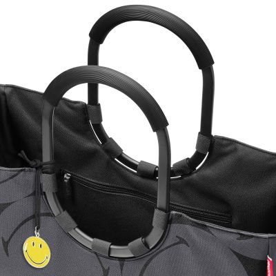 Großer Shopper von Reisenthel, Modell Loopshopper L, in Grau mit großflächigem Smiley-Muster, als Nahaufnahme der Ringgriffe, des Reißverschlusses und des Smiley-Anhängers.