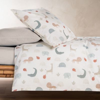 Die Kinderbettwäsche mit Tiermotiven liegt auf einem Kinderbett, das Kissen ist leicht aufgestellt