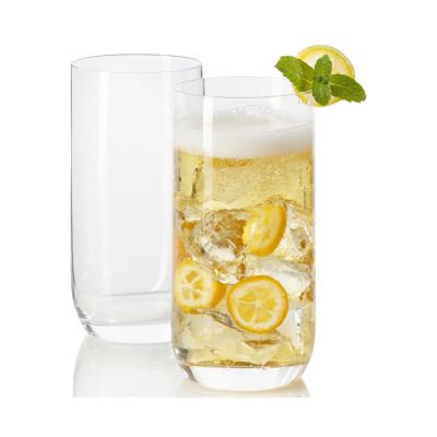 Hohes Longdrinkglas mit hellem Getränk Eiswürfeln Zitronenscheiben und Minze daneben ein leeres Glas