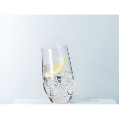 Schräg stehendes Longdrinkglas mit Eiswürfeln und Zitronenscheibe