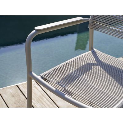 Nahaufnahme der Armlehne eines Gartenstuhls neben Wasserfläche