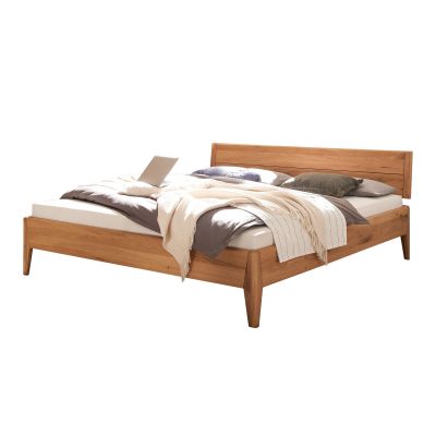 Bett aus Holz mit Kopfteil und Decke freigestellt auf weißem Hintergrund