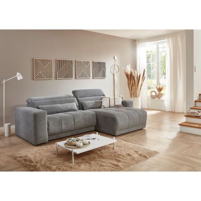 Graues Ecksofa mit Ottomane und verstellbaren Rückenlehnen in einem hellen Wohnzimmer mit Couchtisch und Dekoration